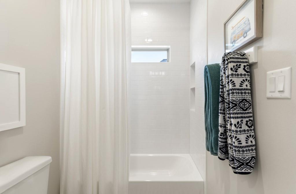 23630 Champion Drive Lindale, TX 75771 - Photo 23 of 36 a bathroom with a shower curtain and a toilet