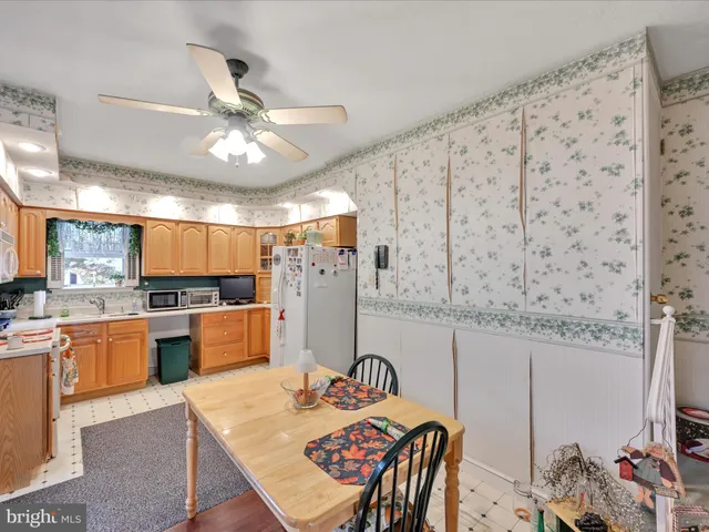 a kitchen with stainless steel appliances kitchen island granite countertop a table chairs in it and wooden floors