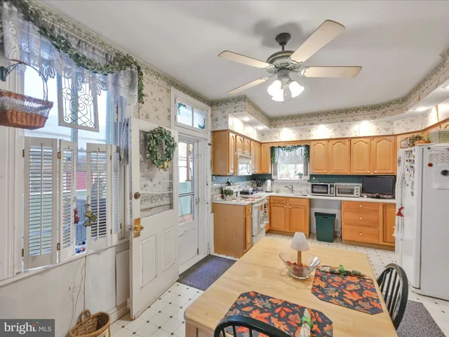 a kitchen with stainless steel appliances kitchen island granite countertop a refrigerator a stove a sink dishwasher a dining table and chairs with wooden floor