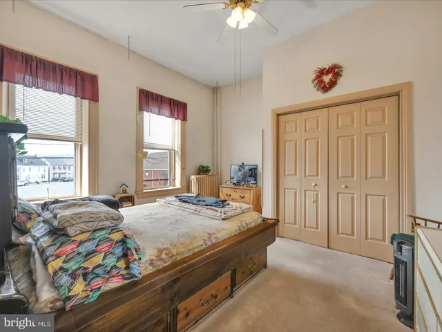 a bedroom with a bed dresser and a window