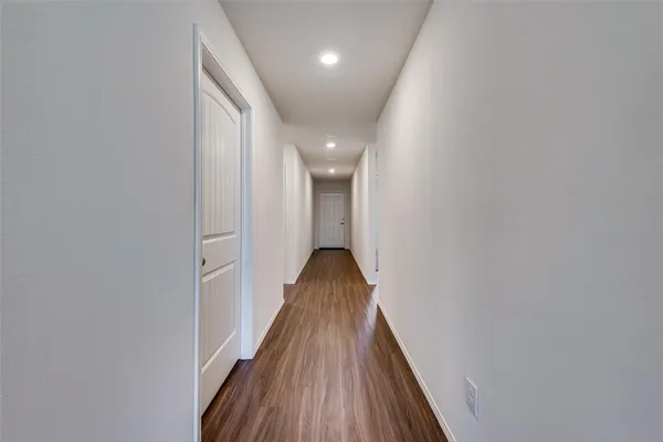 a view of a hallway with wooden floor