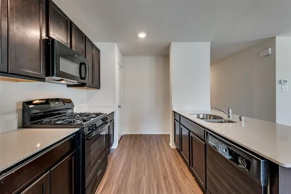 a kitchen with stainless steel appliances a sink stove top oven and cabinets