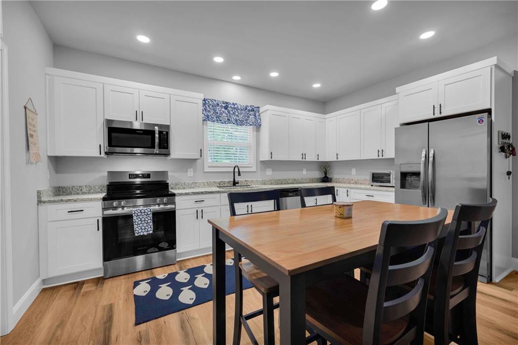 397 Normandy Trail Lavonia, GA 30553 - Photo 15 of 47 a large kitchen with kitchen island a dining table and chairs