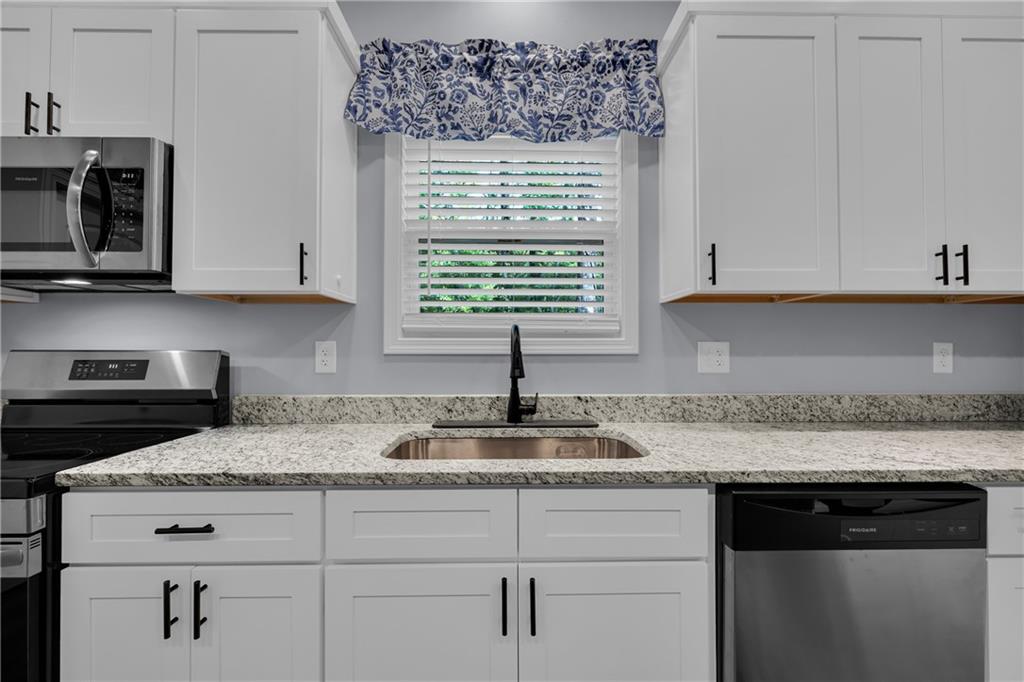 397 Normandy Trail Lavonia, GA 30553 - Photo 19 of 47 a kitchen with granite countertop white cabinets and a stove