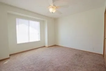 an empty room with a window and a fan