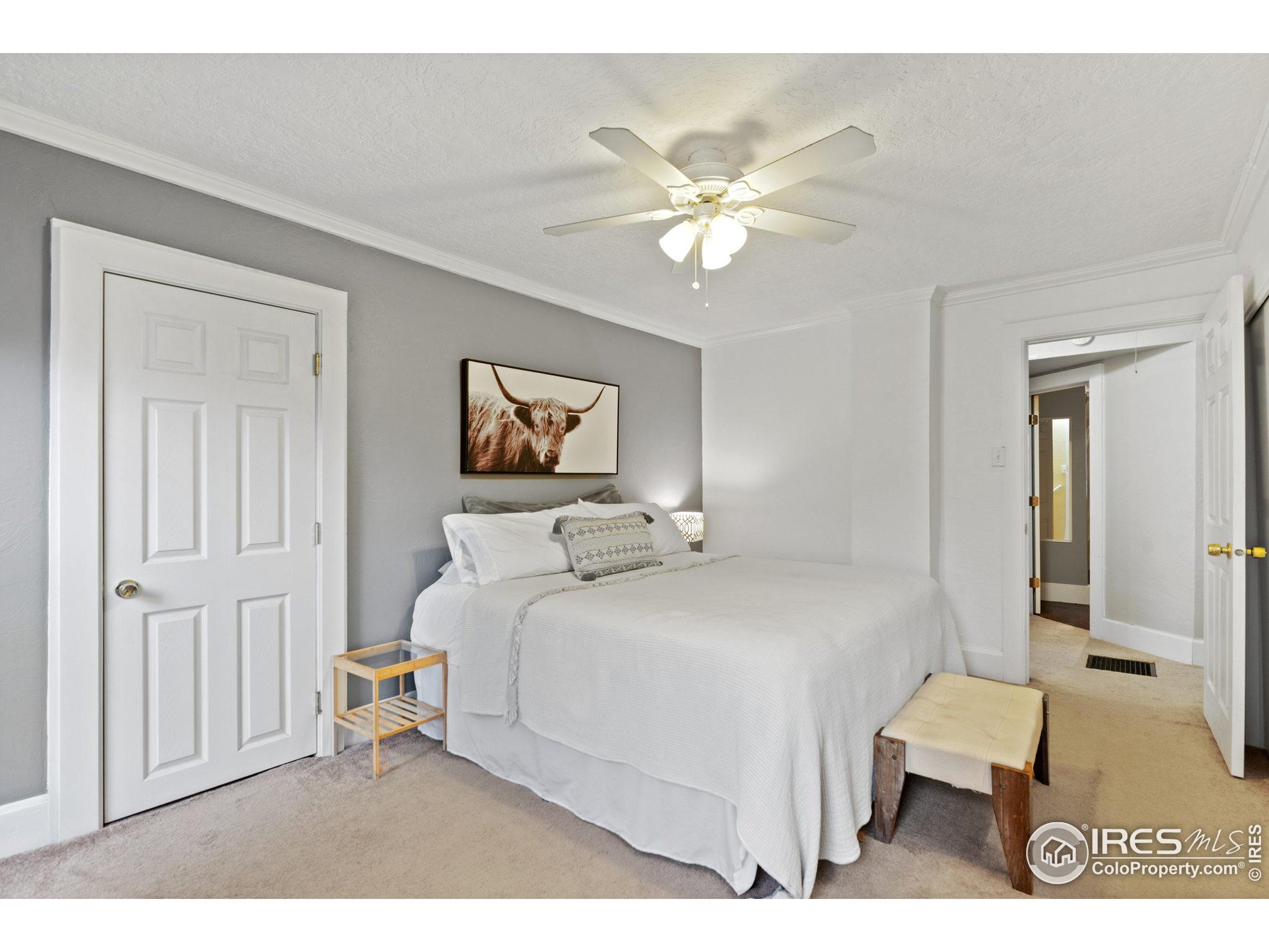 322 Maple Avenue Eaton, CO 80615 - Photo 11 of 26 a bedroom with a bed and a chandelier