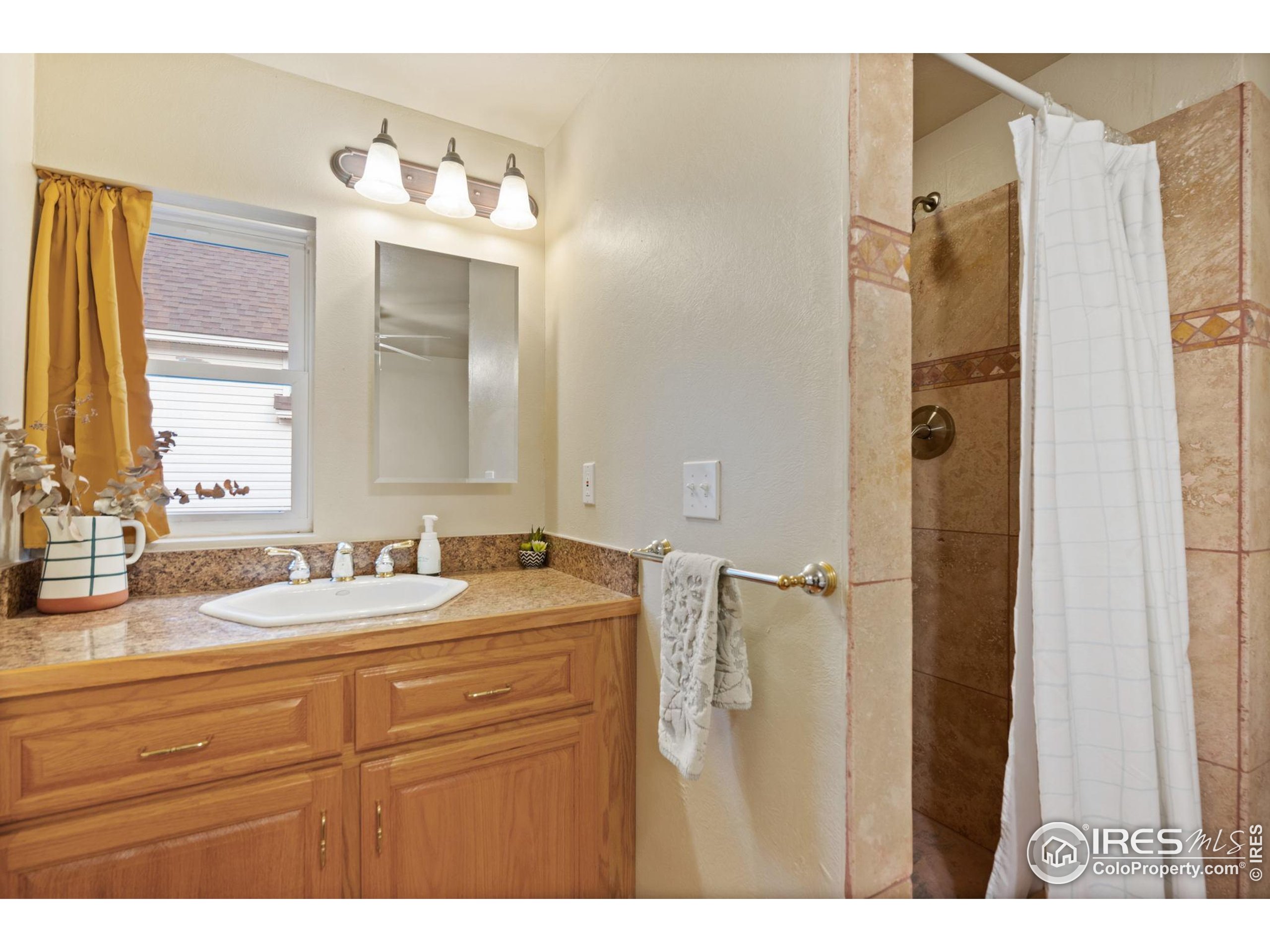 322 Maple Avenue Eaton, CO 80615 - Photo 16 of 26 a bathroom with a sink double vanity and a mirror