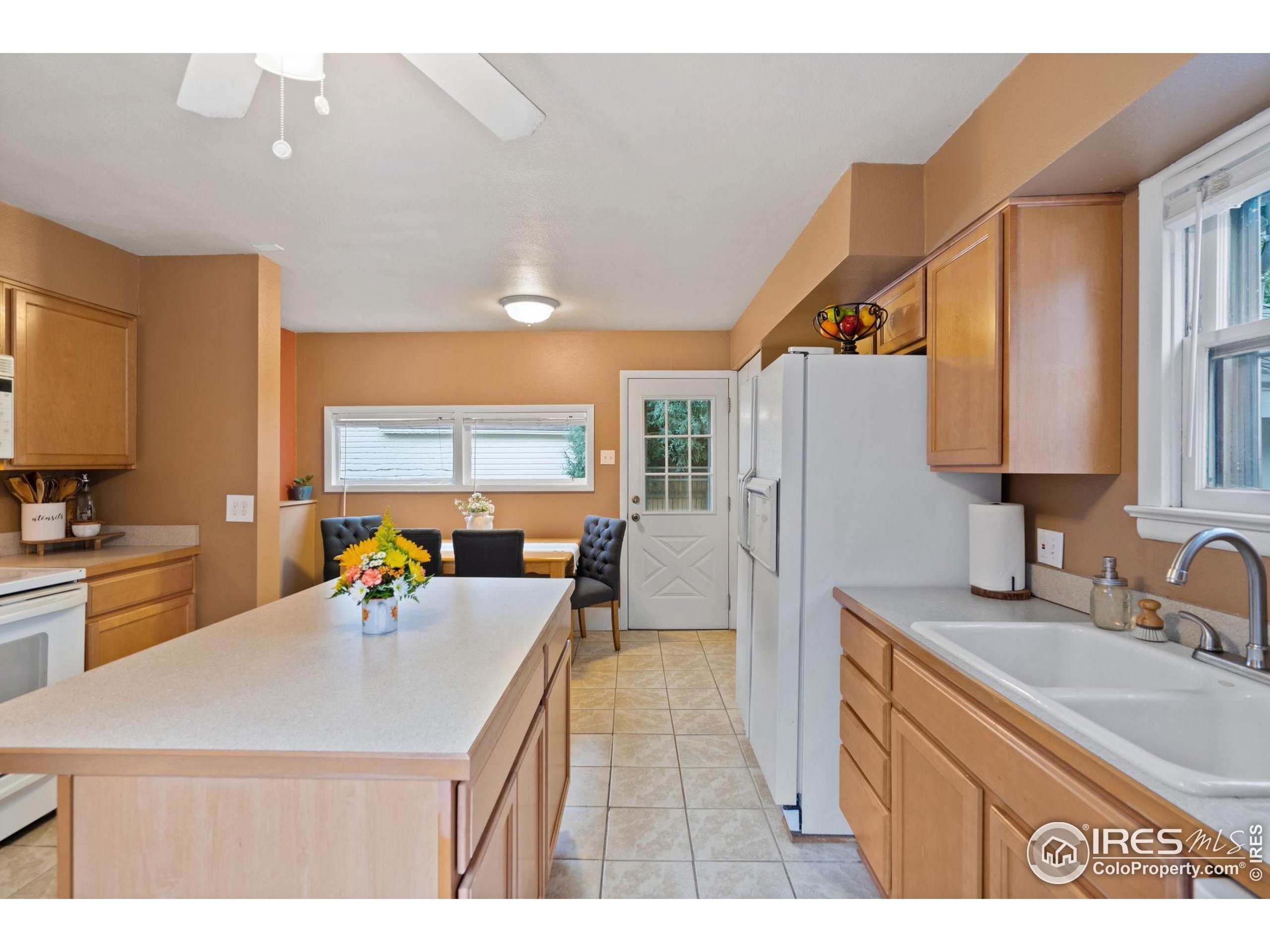 322 Maple Avenue Eaton, CO 80615 - Photo 7 of 26 a kitchen with a sink a counter top space cabinets and stainless steel appliances