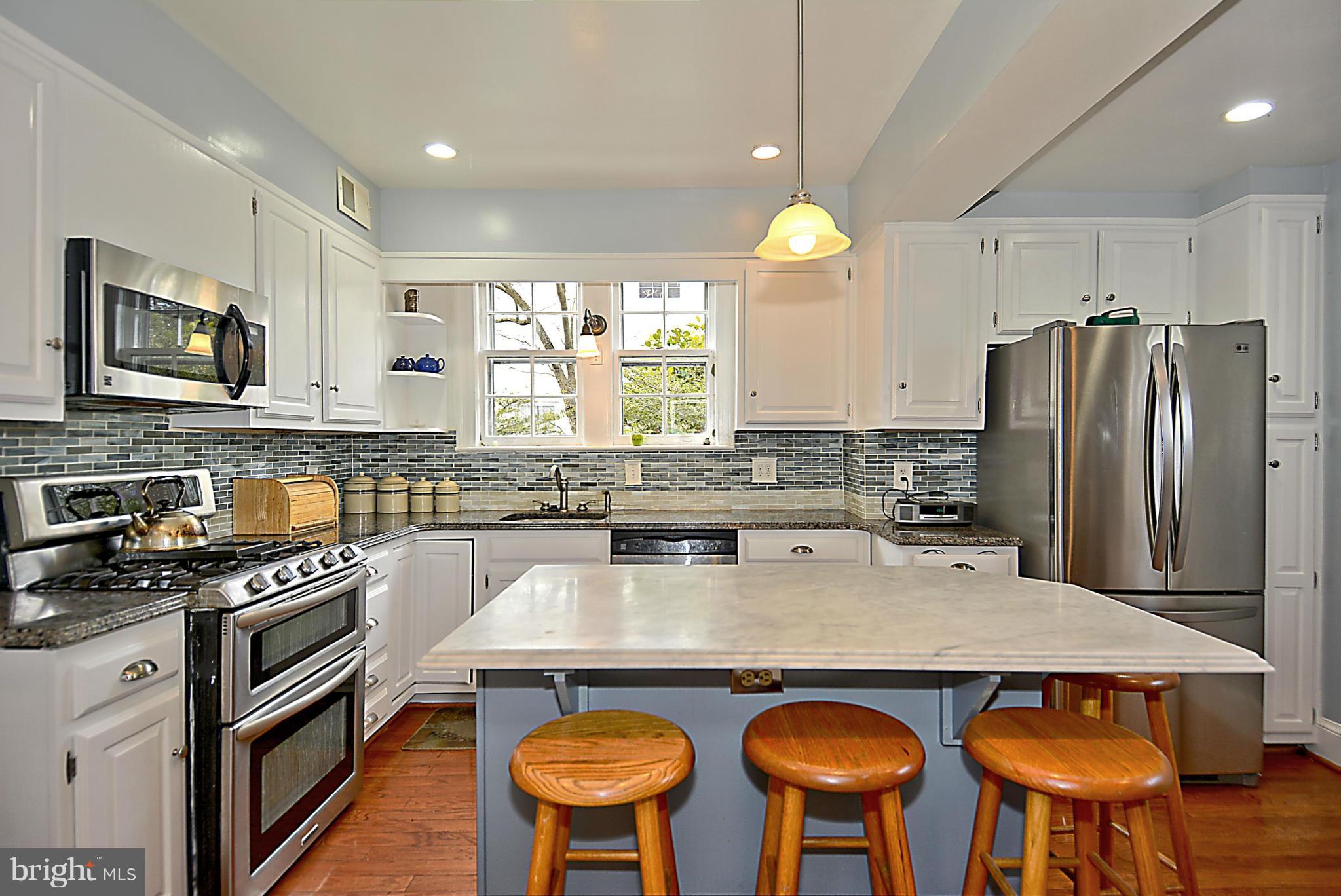 1909 Stratton Road Silver Spring, MD 20910 - Photo 5 of 22 a kitchen with stainless steel appliances granite countertop a stove a refrigerator a sink a dining table and chairs