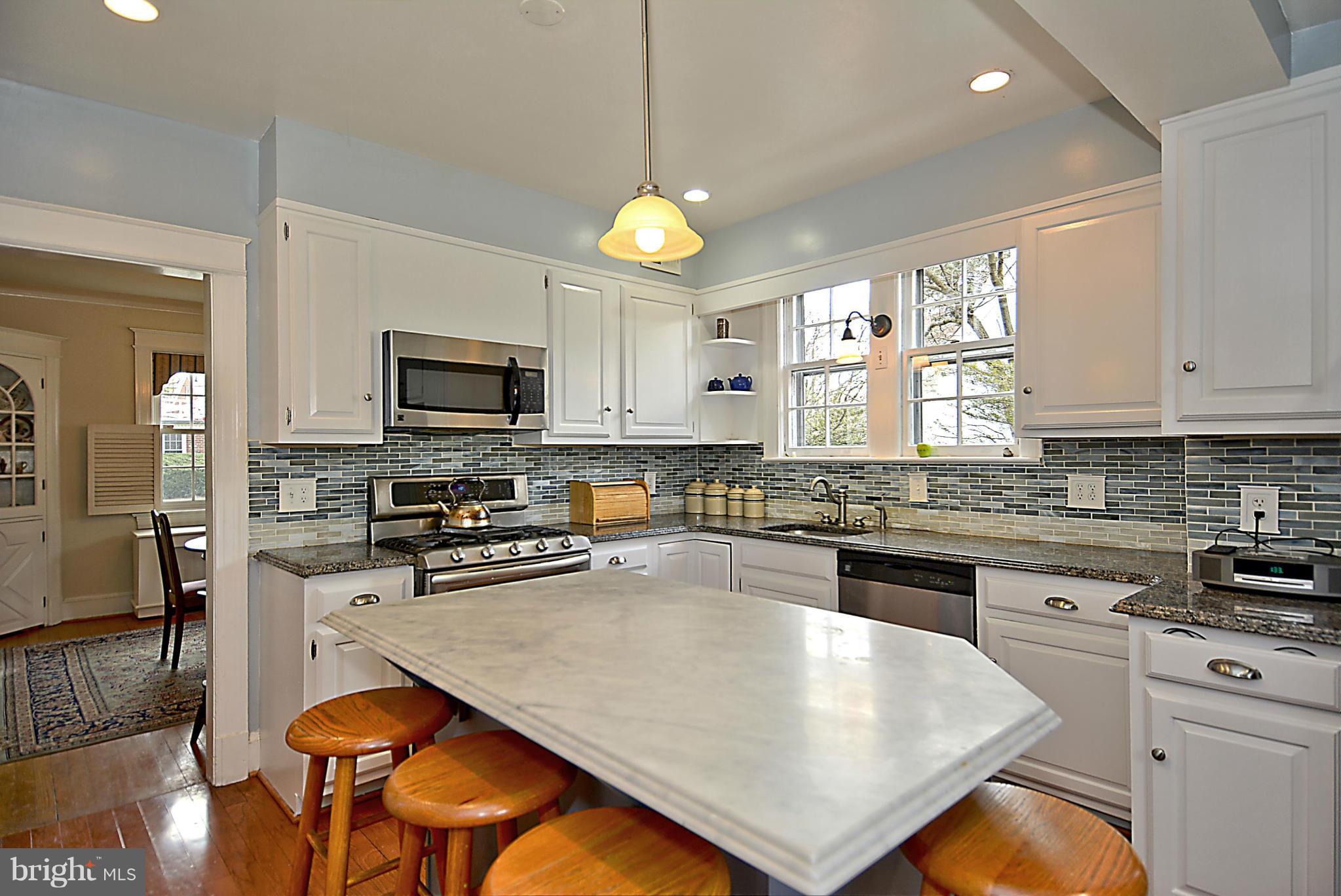 1909 Stratton Road Silver Spring, MD 20910 - Photo 6 of 22 a kitchen with a stove a sink a microwave a dining table and chairs