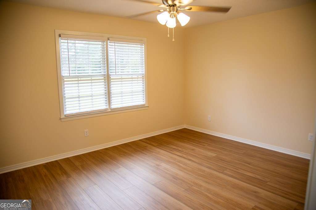 503 Satilla Church Road Baxley, GA 31513 - Photo 28 of 70 a view of an empty room with wooden floor and a window