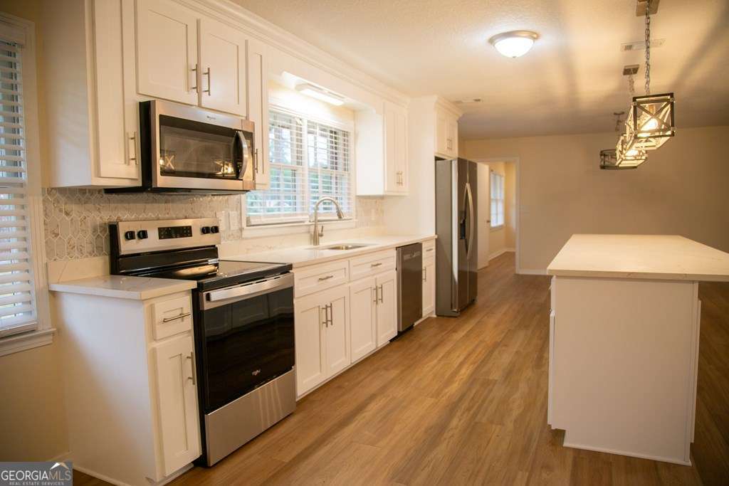 503 Satilla Church Road Baxley, GA 31513 - Photo 41 of 70 a kitchen with stainless steel appliances a stove microwave and sink