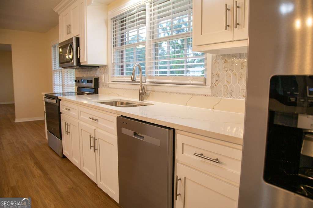 503 Satilla Church Road Baxley, GA 31513 - Photo 47 of 70 a kitchen with stainless steel appliances white cabinets and a sink
