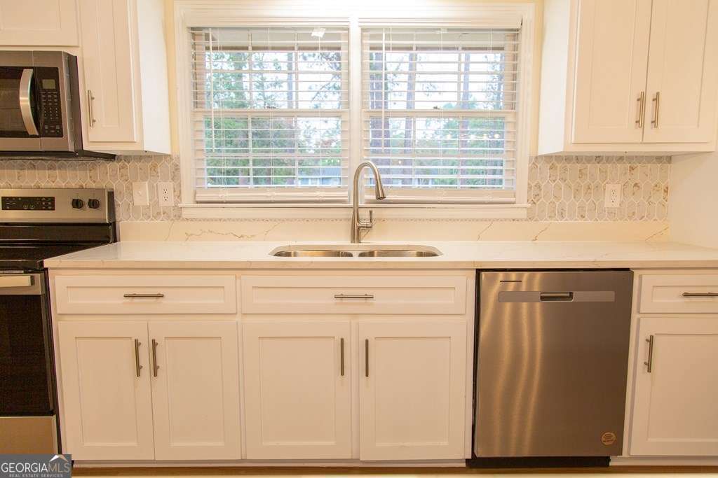 503 Satilla Church Road Baxley, GA 31513 - Photo 49 of 70 a kitchen with granite countertop white cabinets and white appliances