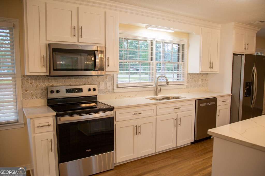 503 Satilla Church Road Baxley, GA 31513 - Photo 50 of 70 a kitchen with white cabinets and stainless steel appliances