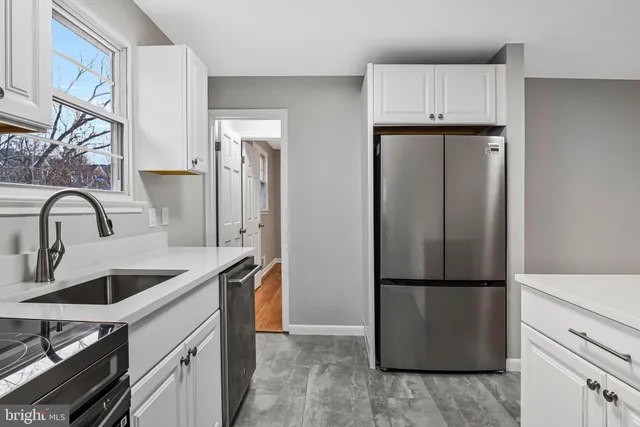 a kitchen with granite countertop a refrigerator and a sink