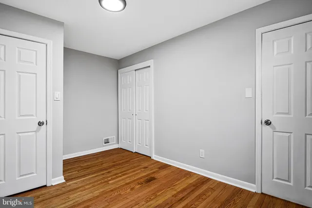 a view of empty room with wooden floor