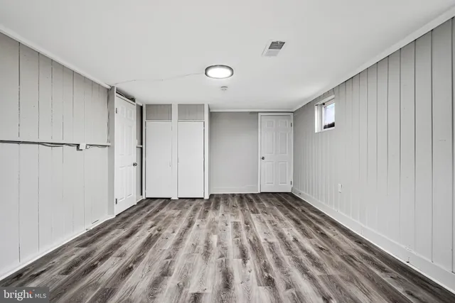 a view of an empty room with closet and a window