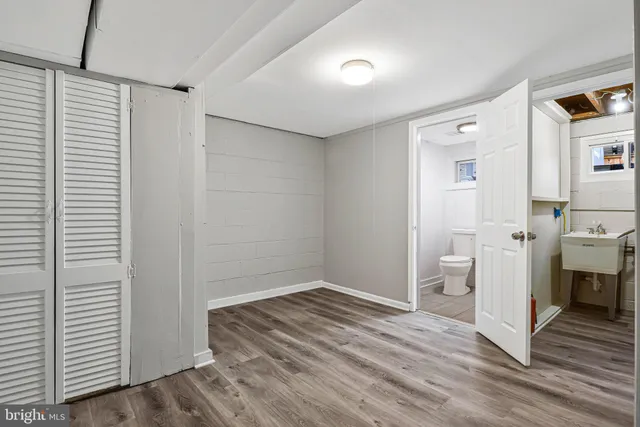 a view of utility room with closet and wooden floor