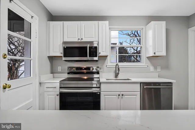 a kitchen with cabinets stainless steel appliances and wooden floor