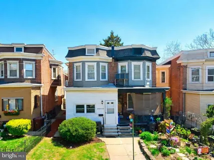 a front view of a house with a yard and trees