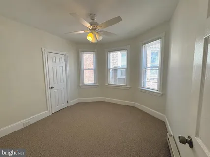 an empty room with windows and fan