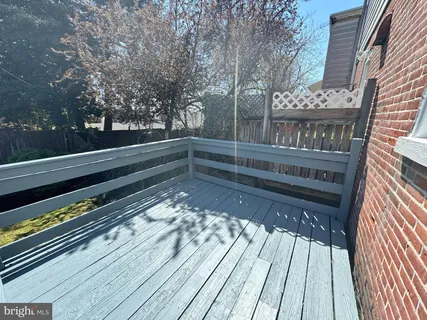 a view of backyard with wooden floor and fence