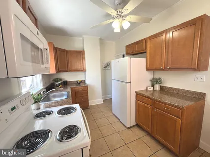 a kitchen with a refrigerator a stove a sink cabinets and a counter top space