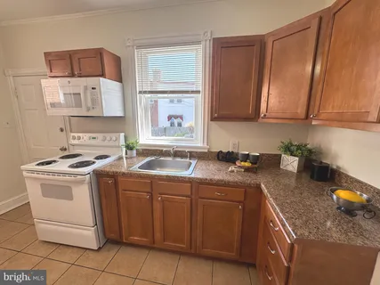 a kitchen with a sink stove top oven and cabinets