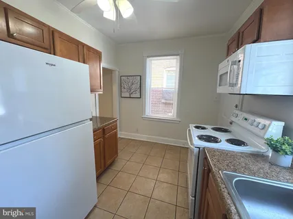 a kitchen with a refrigerator sink and cabinets