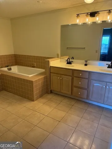 a bathroom with a tub sink and mirror