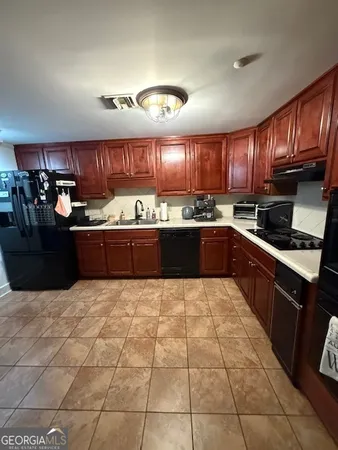 a large kitchen with granite countertop a stove a sink dishwasher and a refrigerator