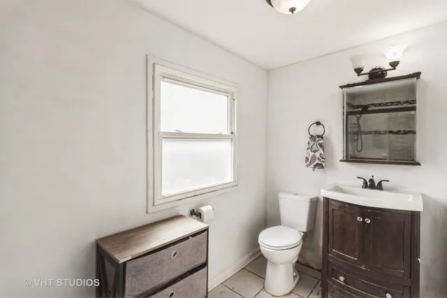 a bathroom with a toilet sink vanity and mirror