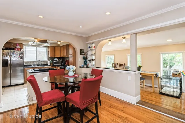 a dining room with furniture a floor to ceiling window and wooden floor