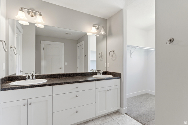 1614 Aspen Loop Provo, UT 84606 - Photo 24 of 47 Double vanity with white cabinetry, dark countertop, dual undermount sinks, and chrome faucets