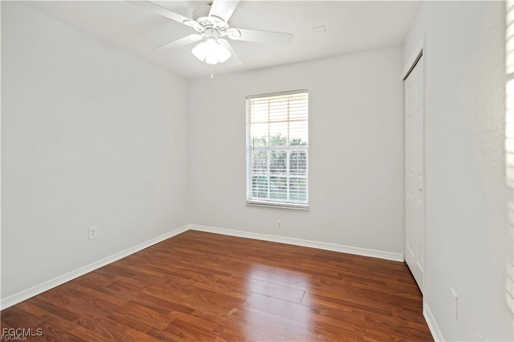 260 13th Street Southwest Naples, FL 34117 - Photo 18 of 29 an empty room with wooden floor fan and windows