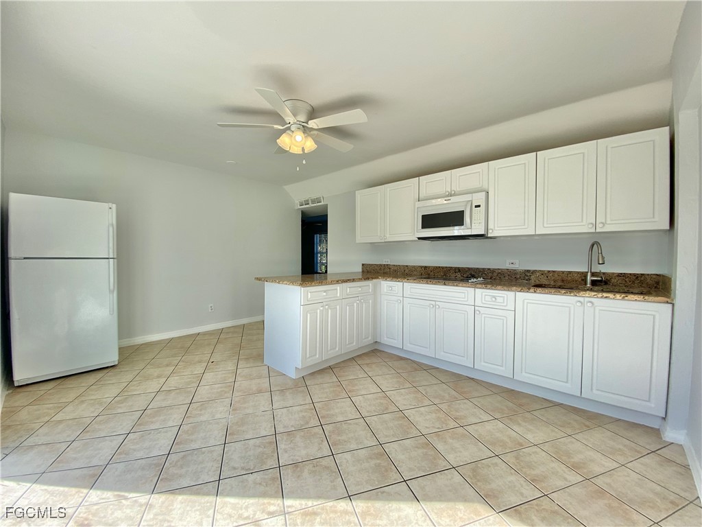 260 13th Street Southwest Naples, FL 34117 - Photo 23 of 29 a kitchen with granite countertop a stove a sink and a refrigerator