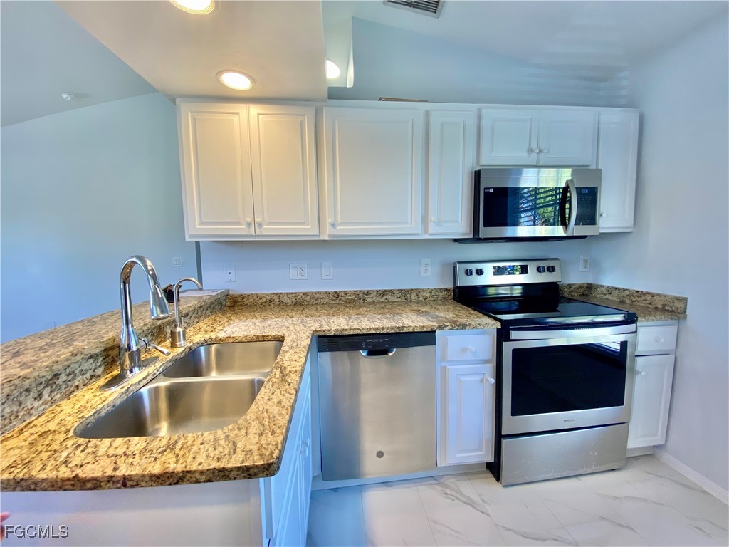 260 13th Street Southwest Naples, FL 34117 - Photo 26 of 29 a kitchen with granite countertop a sink stove and microwave