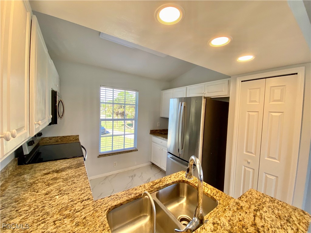 260 13th Street Southwest Naples, FL 34117 - Photo 27 of 29 a bedroom with a bed and a dresser next to a window