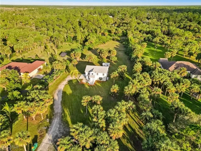 a living room with furniture kitchen view and a chandelier