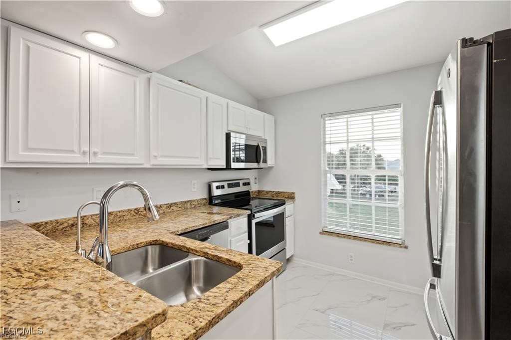 260 13th Street Southwest Naples, FL 34117 - Photo 8 of 29 a kitchen with a sink cabinets and stainless steel appliances
