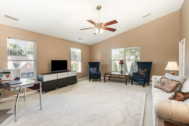 a living room with furniture a chandelier and a large window