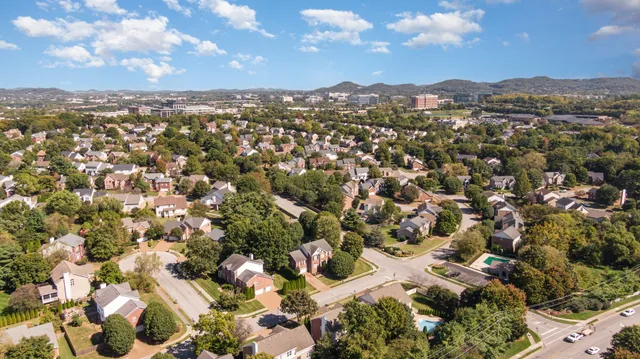 an aerial view of residential houses with outdoor space and trees