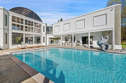 a view of a swimming pool with a patio and a yard