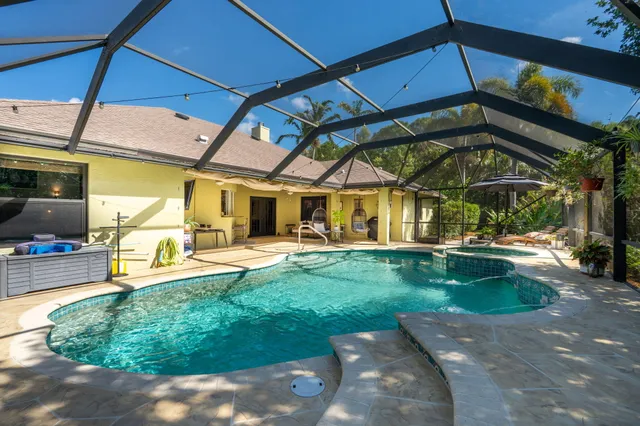 a kitchen with stainless steel appliances granite countertop a refrigerator a sink a stove top oven and a refrigerator