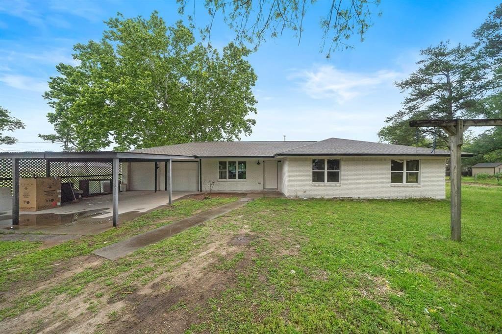 a front view of house with yard and trees in the background