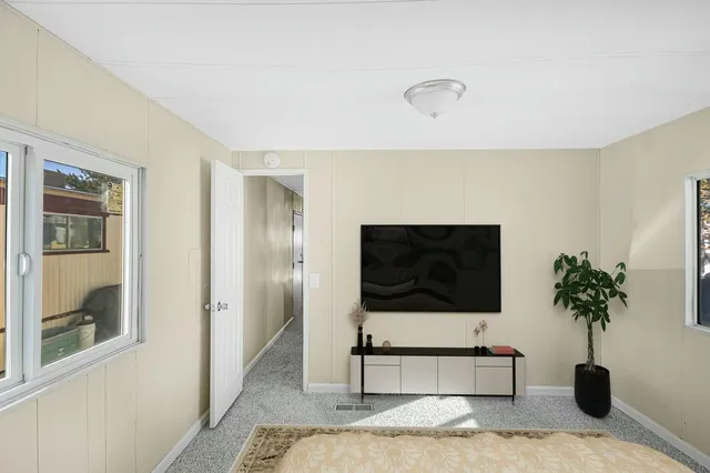 a bedroom with a bed and a potted plant