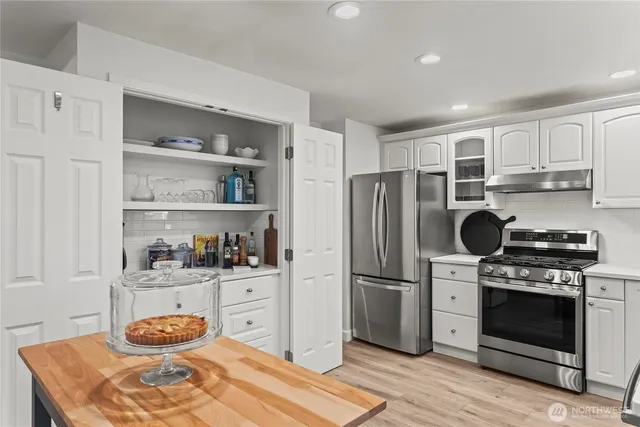 a kitchen with stainless steel appliances granite countertop a stove a refrigerator and cabinets