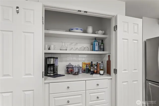 a kitchen with white cabinets and wooden floor