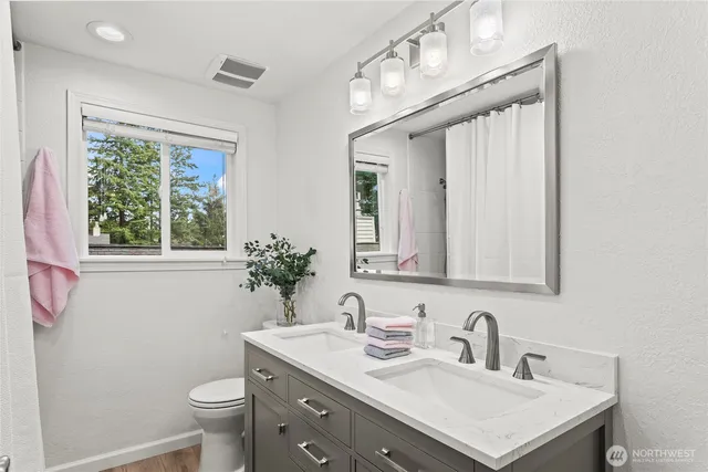 a bathroom with a sink vanity granite and a toilet